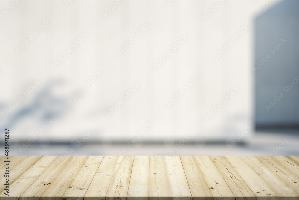 Blank wooden office desk with light building wall on background, mock up