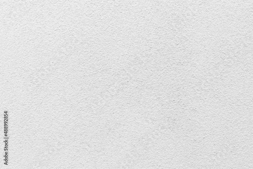 Sample of a texture of white plaster. Wall finished with a decorative cement stucco. Example of exterior building decoration. Clean uniform grainy background. Banner. Wallpaper. Copy space. Pattern