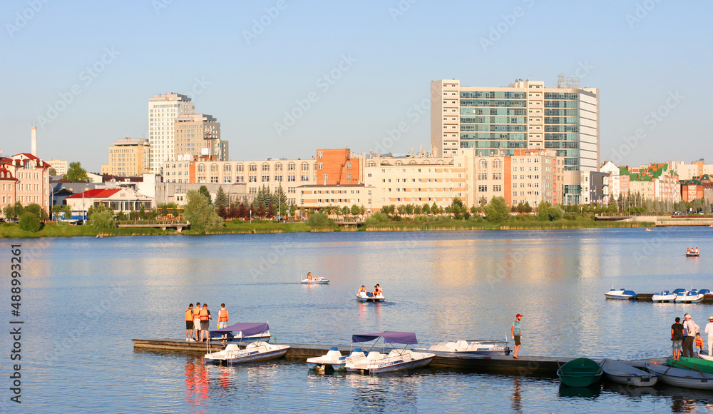 The Lake Nizhny Kaban. Kazan, Tatarstan, Russia: July 14 2021. The embankment of the Lower Kaban Lake. Tourists are walking and boating. Photo with copy space. Panoramic view of the embankment