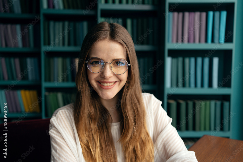 Portrait of a female student manager with glasses in the library. Portrait of a female student manager with glasses in the library.