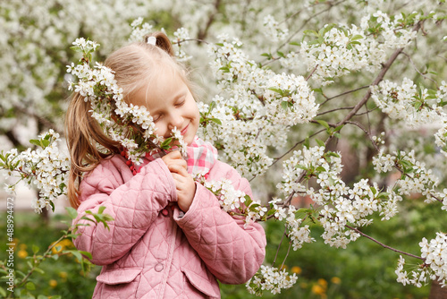 Child spring garden. Little girl blossoming cherry branch dreams