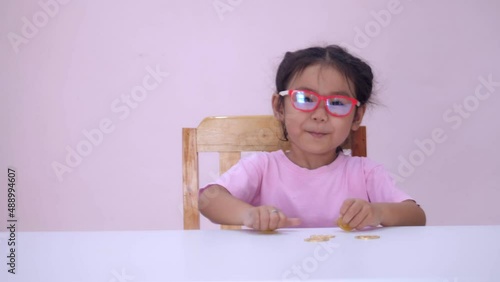 Slow motion scene of a 5-year-old Asian girl collecting bitcoins. fun at the table
