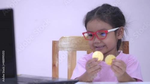 Slow motion scene of a 5-year-old Asian girl collecting bitcoins. fun at the table
