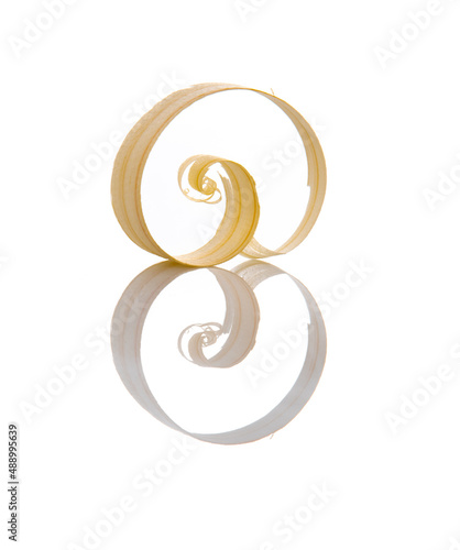 Wood shavings set on a white isolated background with reflection. The shavings together with the reflection form the number eight 8. Postcard for March 8, Women's Day.