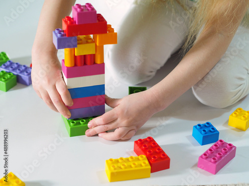 Child girl collects the constructor. Children's educational games.