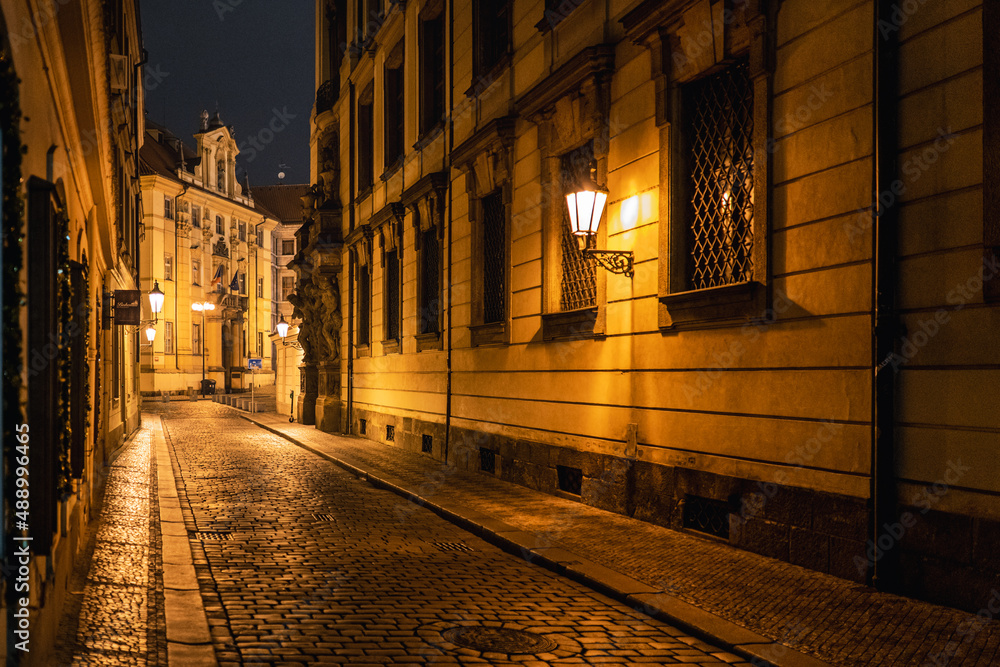 Old narrow street with stone road and lanterns in Prague