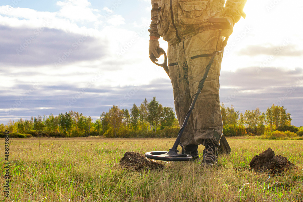 a man with a metal detector looking for artifacts of past years in the ...