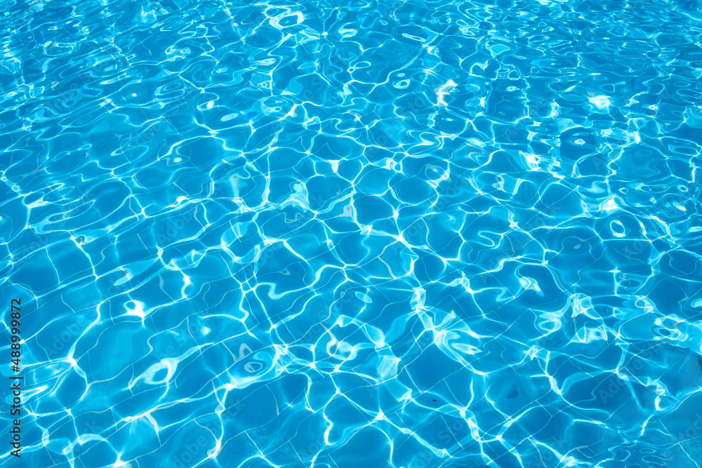 Flat view swimming pool background.Blue water in swimming pool background.Sun glare on the water,travel background