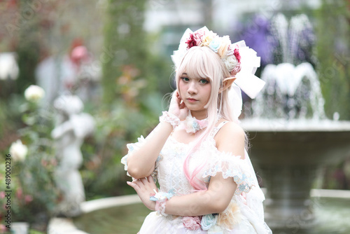 Beautiful young woman with white lolita dress with flowers garden Japanese fashion photo