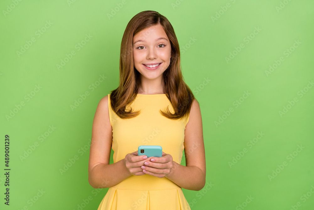 Photo of youth cheerful lady use mibile phone chat type comment button isolated over green color background Photo of youth cheerful lady use mibile phone chat type comment button isolated over green color background
