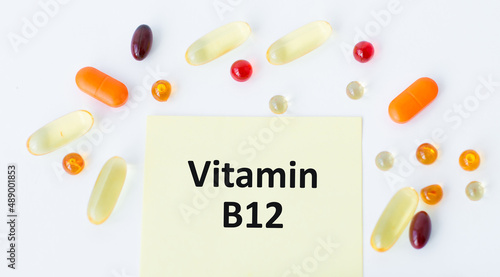 vitamin B12 inscription on a card on a white background around scattered tablets photo