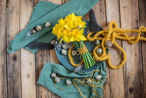 Tisch Dekoration Frühling und Ostern mit Narzissen und Eiern auf Tellern, Blumenstrauß Frühling photo