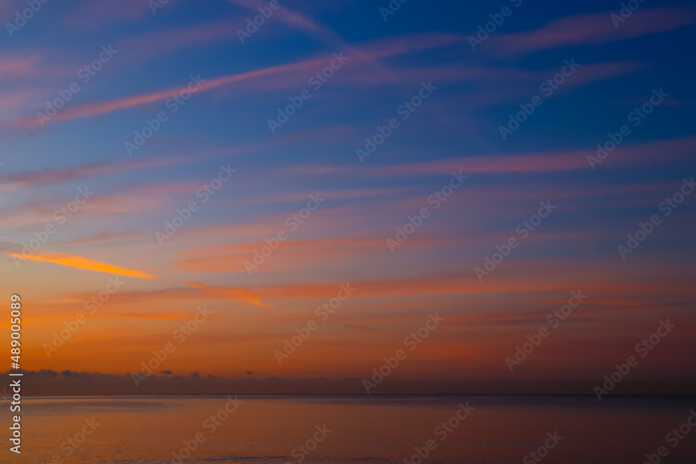 Trazos en el cielo de color naranja al amanecer con fondo azul