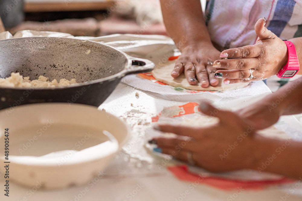 Unknown persons preparing tortillas in an artisanal manner 