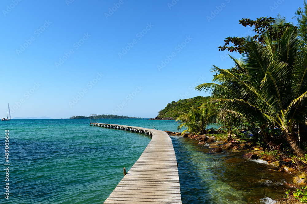 Arched wooden bridge that extends into the sea to serve as a pier, Klong Mard, Koh Kood, Trat, Thailand.