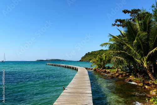 Arched wooden bridge that extends into the sea to serve as a pier, Klong Mard, Koh Kood, Trat, Thailand. © ULTRAPOK