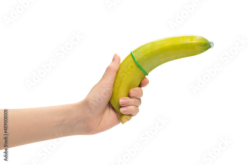 Woman put on a condom on a banana. Isolated on white background.