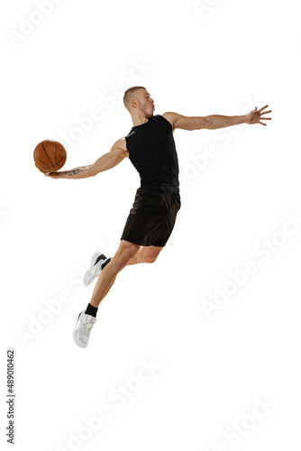Dynamic portrait of muscled man, basketball player jumping with ball isolated on white studio background. Sport, motion, activity concepts. © master1305