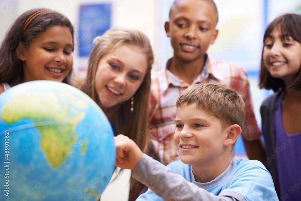 Here it is - Geography class. A group of pupils looking at a globe during geography class. Here it is - Geography class. A group of pupils looking at a globe during geography class.