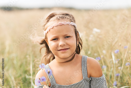 .Beautiful girl with a bouquet of wildflowers on a meadow in sunlight. Summer background.