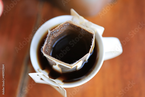 top view closeup sachet drip coffee ear in a white cup photo