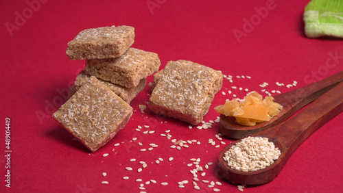 Indian makar sankranti festival food or sweets. Tilgul in a small bowl. Tilgul is made out of sesame seeds, peanuts, and jaggery. Til gud chikki or sesame candy. Copy Space.