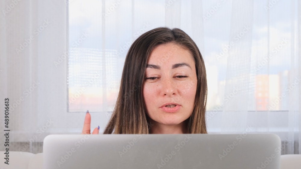 brunette girl blogger talking with friends on social networks on laptop using wireless internet. Positive young woman shopping online on the website brunette girl blogger talking with friends on social networks on laptop using wireless internet. Positive young woman shopping online on the website