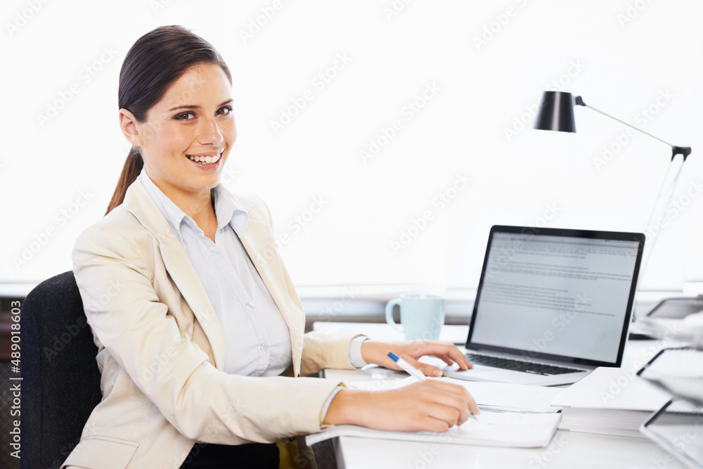 Total job satisfaction. Portrait of a young businesswoman sitting at a desk in an office. Total job satisfaction. Portrait of a young businesswoman sitting at a desk in an office.