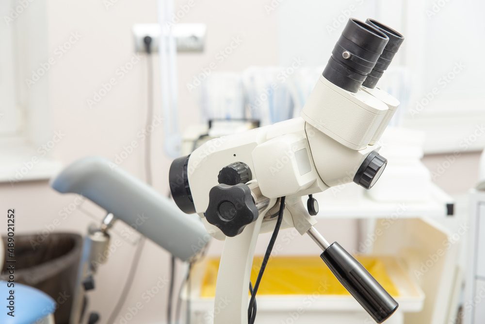 Colposcope closeup on the background of gynecological chair. Colposcope closeup on the background of gynecological chair.