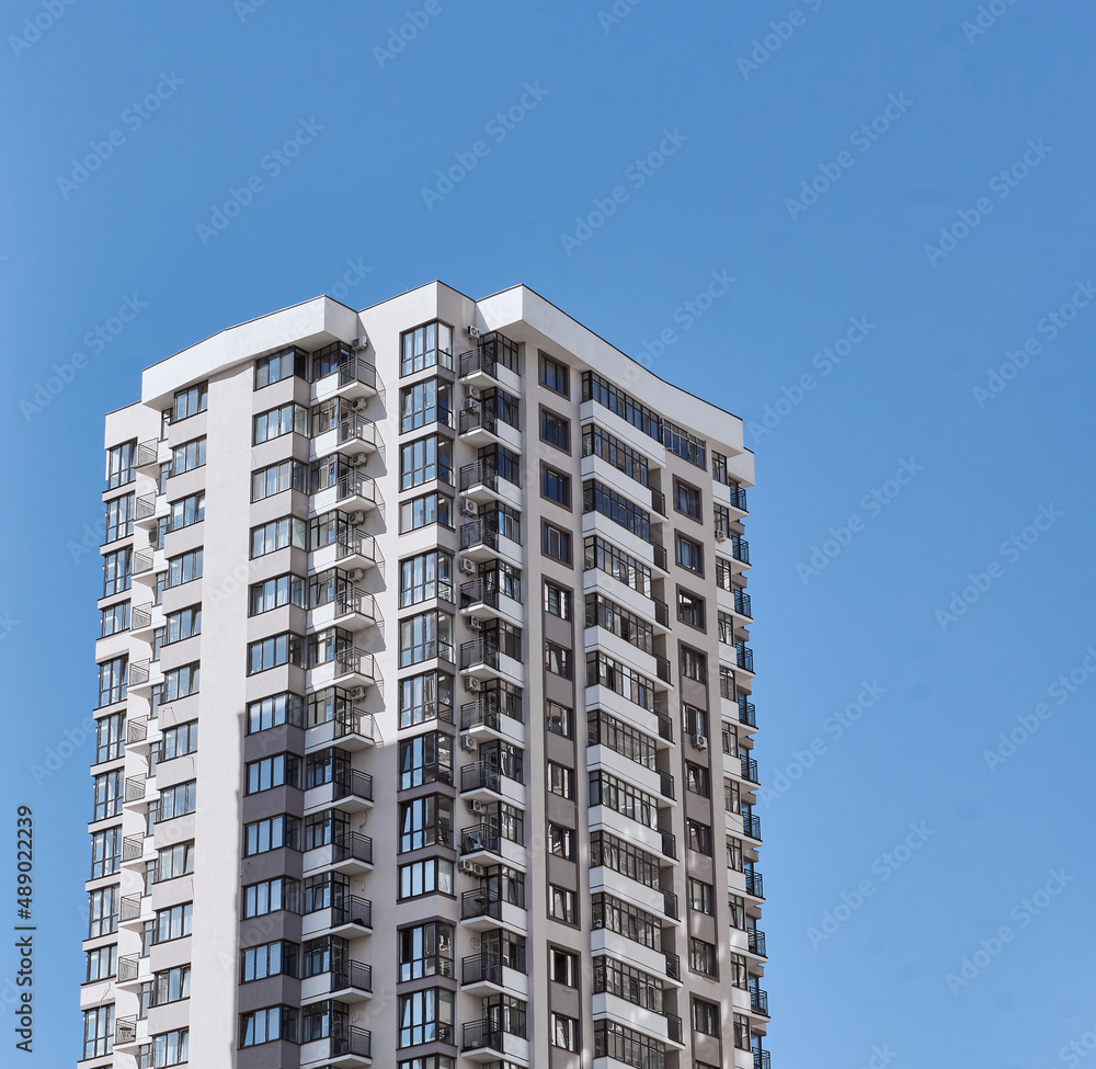 Modern new residential concrete high-rises on a background of the sky. Front view part of multi-storey new built. Modern multi-storey residential area. Residential fund.