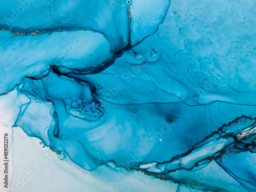 Background texture of alcohol ink in blue color. Abstract paint with drops and stains.