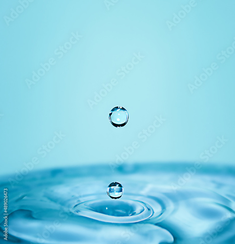 Falling water drops in macro. Vertical photography.