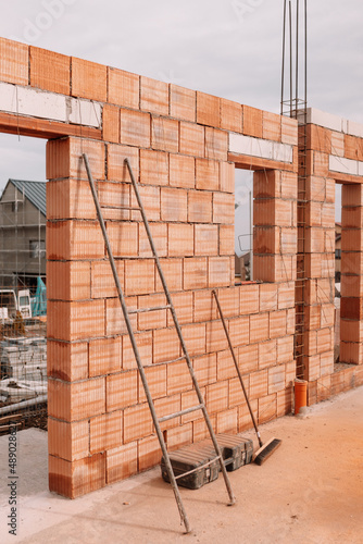 Construction industry details - industrial bricklayer installing bricks on construction site..