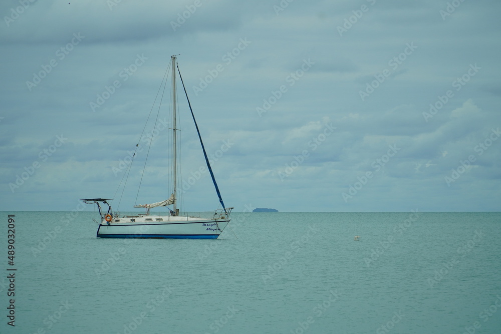 Fototapeta premium anchored sailboat mountains behind