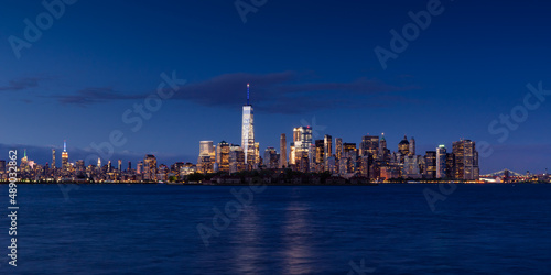 New York City Lower Manhattan cityscape in evening. View of Financial District skyscrapers with World Trade Center, Midtown West and Ellis Island