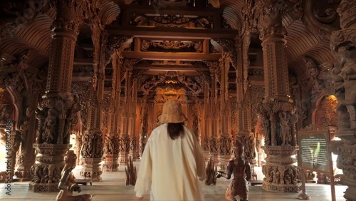 Sanctuary of Truth (Prasat Sut Ja-Tum), Rear view of woman 
tourist at beautiful Thai wooden temple interior in Pattaya Thailand, Amazing Thailand travel concept.