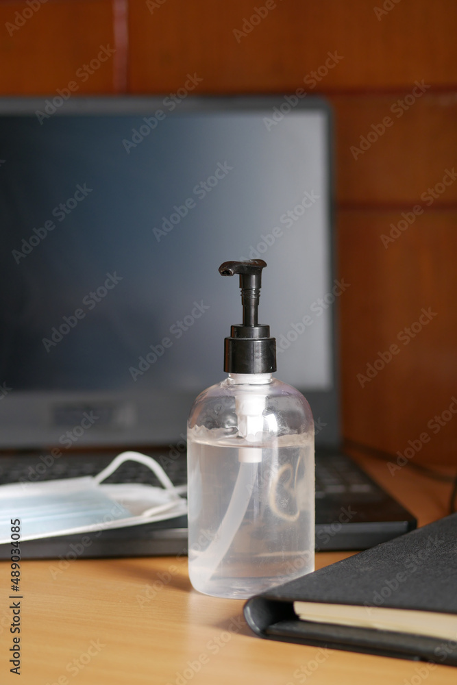 Close up of blue surgical masks and hand sanitizer on table 