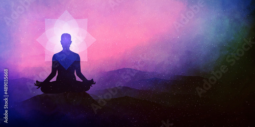 practices yoga and meditating on the mountain sunset background