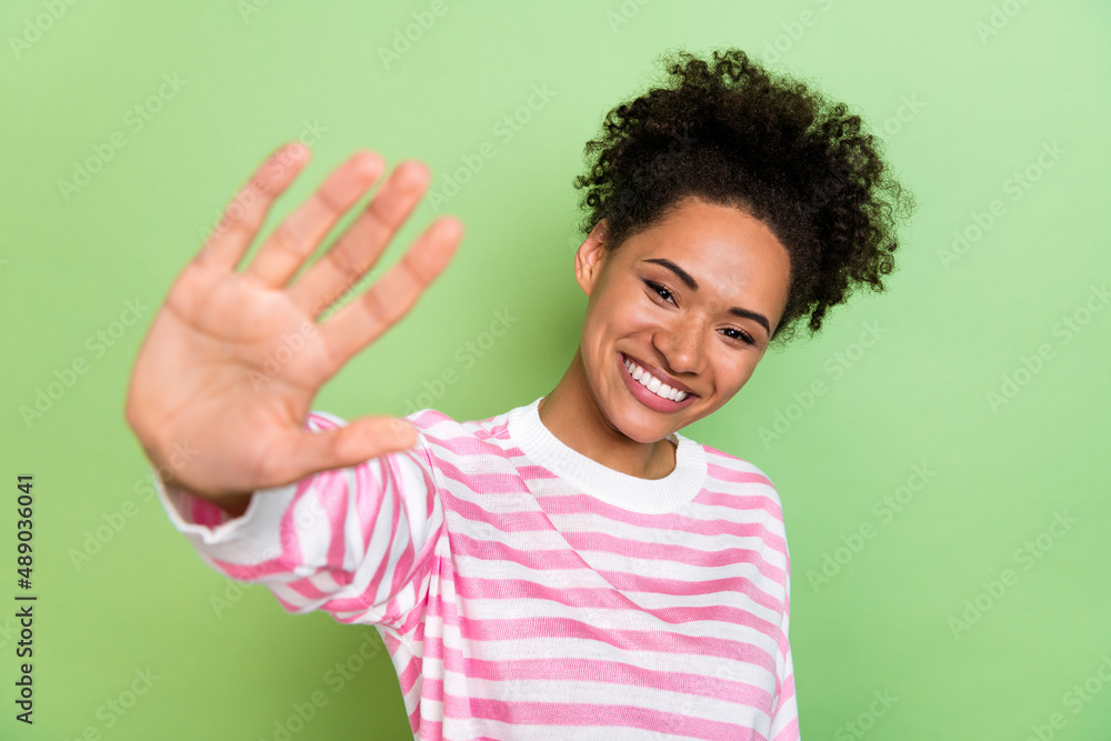 Photo of charismatic lady give you high five make video call wear striped shirt isolated green color background Photo of charismatic lady give you high five make video call wear striped shirt isolated green color background