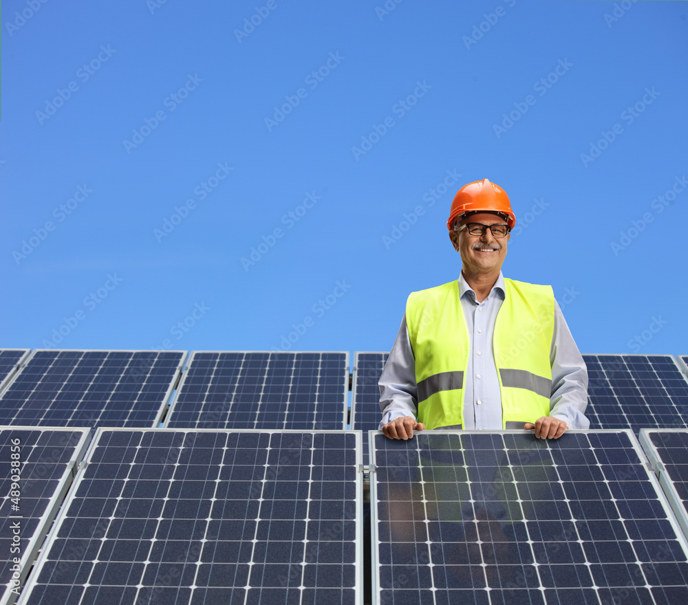 Engineer standing behind solar panels Engineer standing behind solar panels
