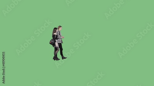 A young guy in a plaid shirt and a girl in a short skirt are walking together. Alpha channel included
