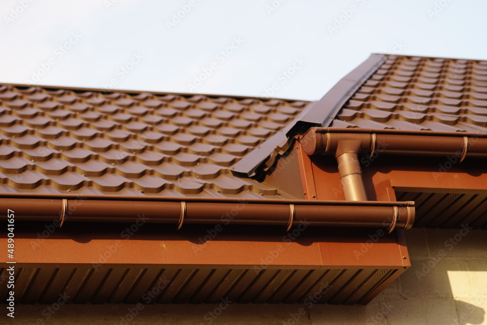 Fototapeta premium Close-up of modern brown tiled roof in sunny day