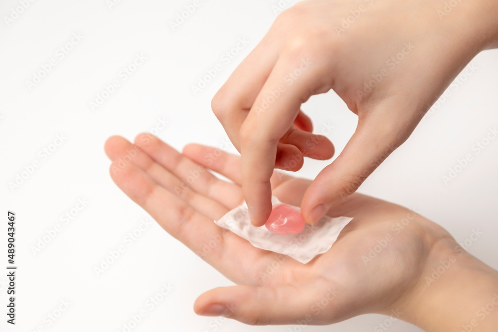 Children's hands open a pink lollipop on the palm. Children's hands open a pink lollipop on the palm.