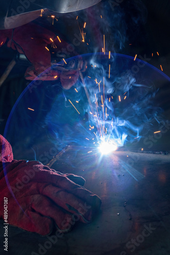 Worker welds a heating stove photo