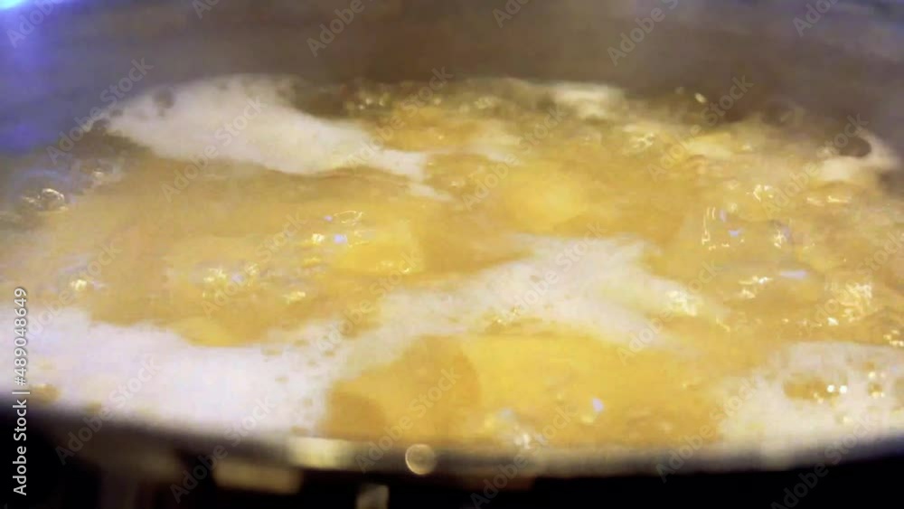 Pot on the stove with boiling water with some pasta that is cooking Pot on the stove with boiling water with some pasta that is cooking
