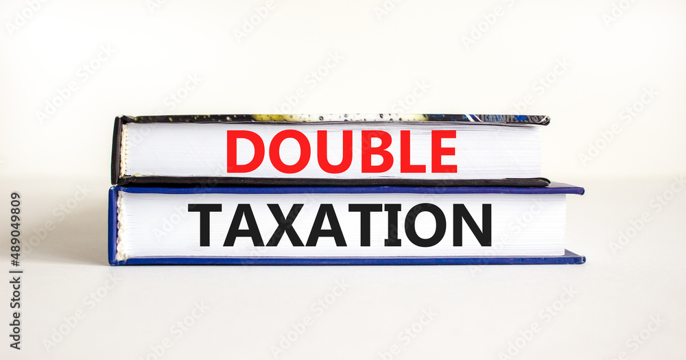 Double taxation symbol. Concept words Double taxation on books on a beautiful white table white background. Business tax and double taxation concept, copy space.