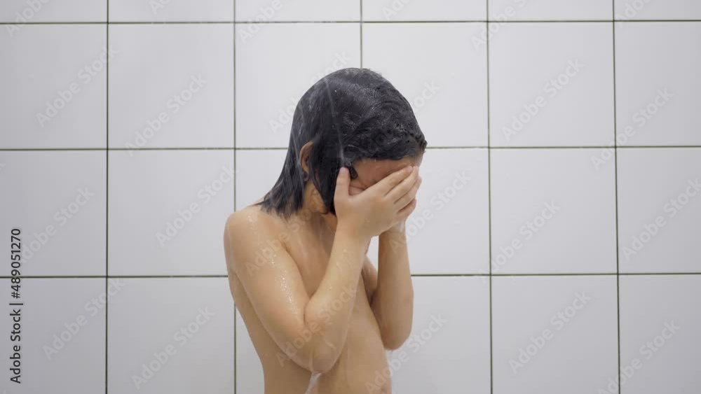 boy child 5 years old brunette with long hair washes in the bathroom and sings in the shower with white tiles in a square boy child 5 years old brunette with long hair washes in the bathroom and sings in the shower with white tiles in a square