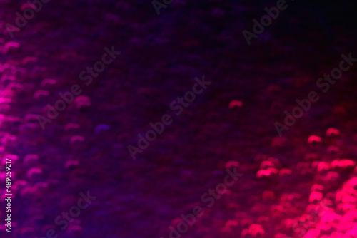 Defocused sparks. Neon glow background. Strokes flare pattern. Blur ultraviolet pink purple color light curved flecks on dark black overlay.