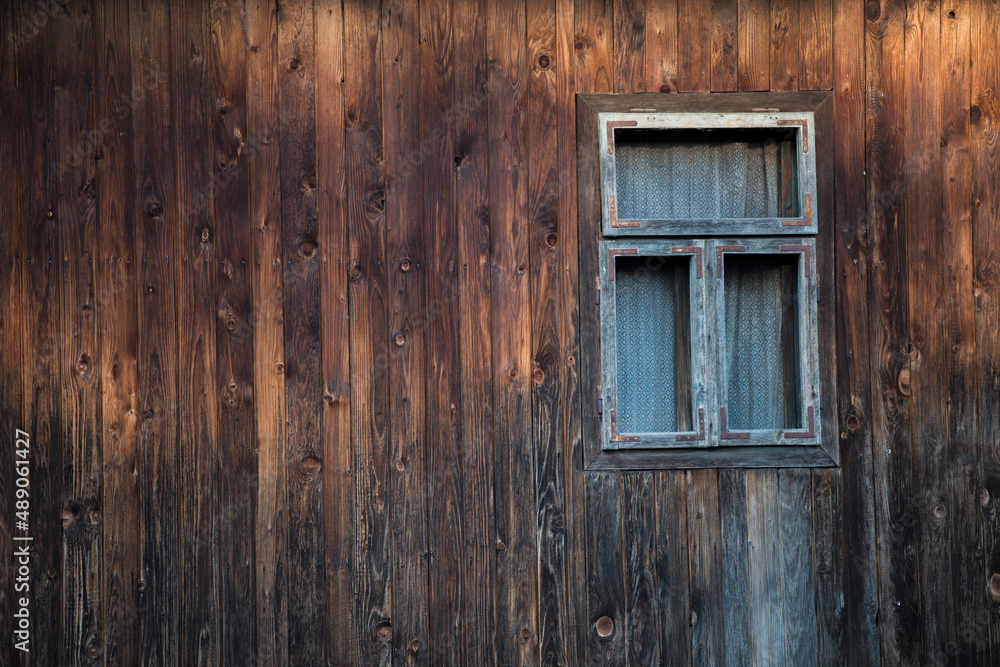 Sunja, Croatia, 05,04,2021: Rustic style aged window in wooden village rural home wall. Sunja, Croatia, 05,04,2021: Rustic style aged window in wooden village rural home wall.