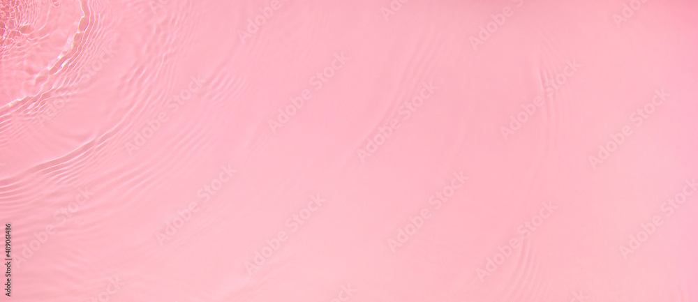 Abstract summer banner background Transparent pink clear water surface texture with ripples, splashes and bubbles. Water waves in sunlight with copy space Cosmetics moisturizer micellar toner emulsion